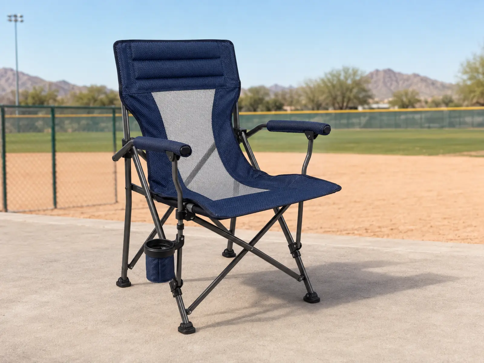 Portable camping chair positioned near the foul line seating area at a Phoenix youth baseball complex.